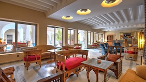 Un hall amplio con mobiliario de madera, ventanas grandes y un diseño de techo moderno.