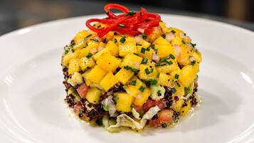 A dish with diced mango, red onion, and black beans on a white plate.