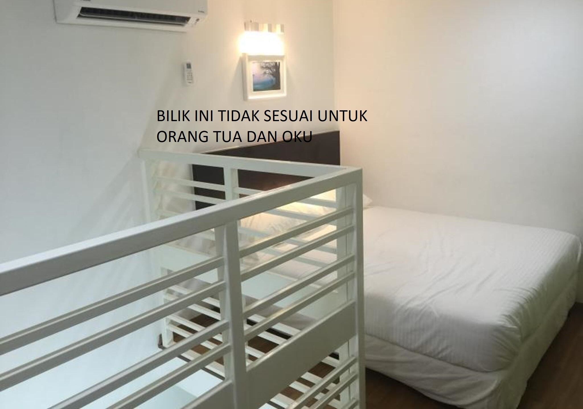 A bedroom with a bed, a white railing, and a wall-mounted air conditioner.