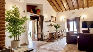 A spacious living area with a high ceiling, a dining table set for six, and a comfortable seating arrangement. - B&B Villa Loriana (Milo)