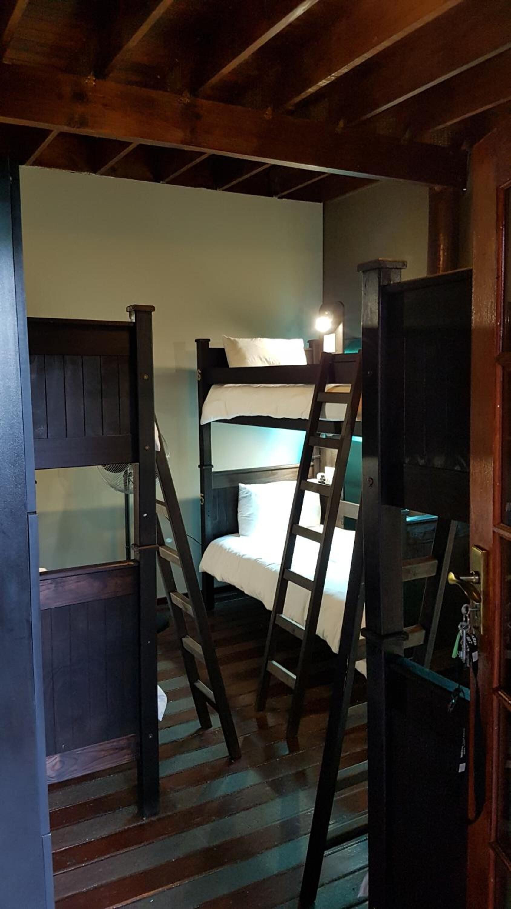Quarto com beliche, escrivaninha e cadeira.