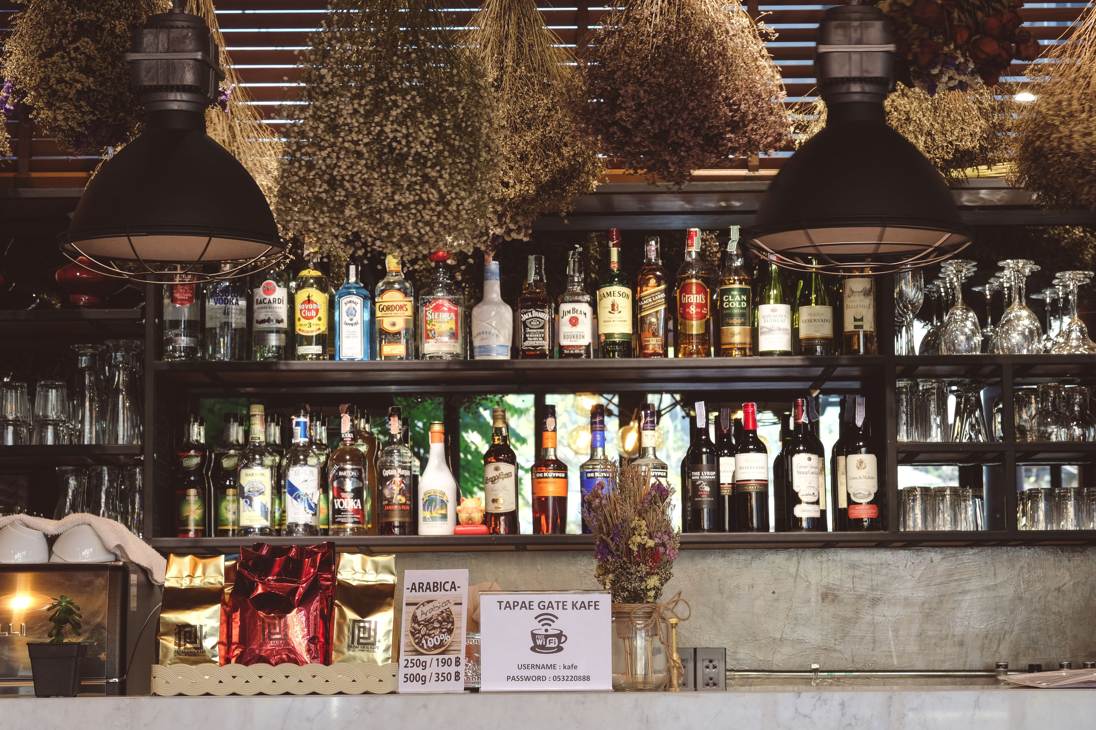Zona de bar con diversas botellas de licor y vasos.