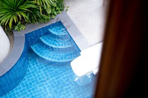 A swimming pool with a curved design and steps leading into the water.