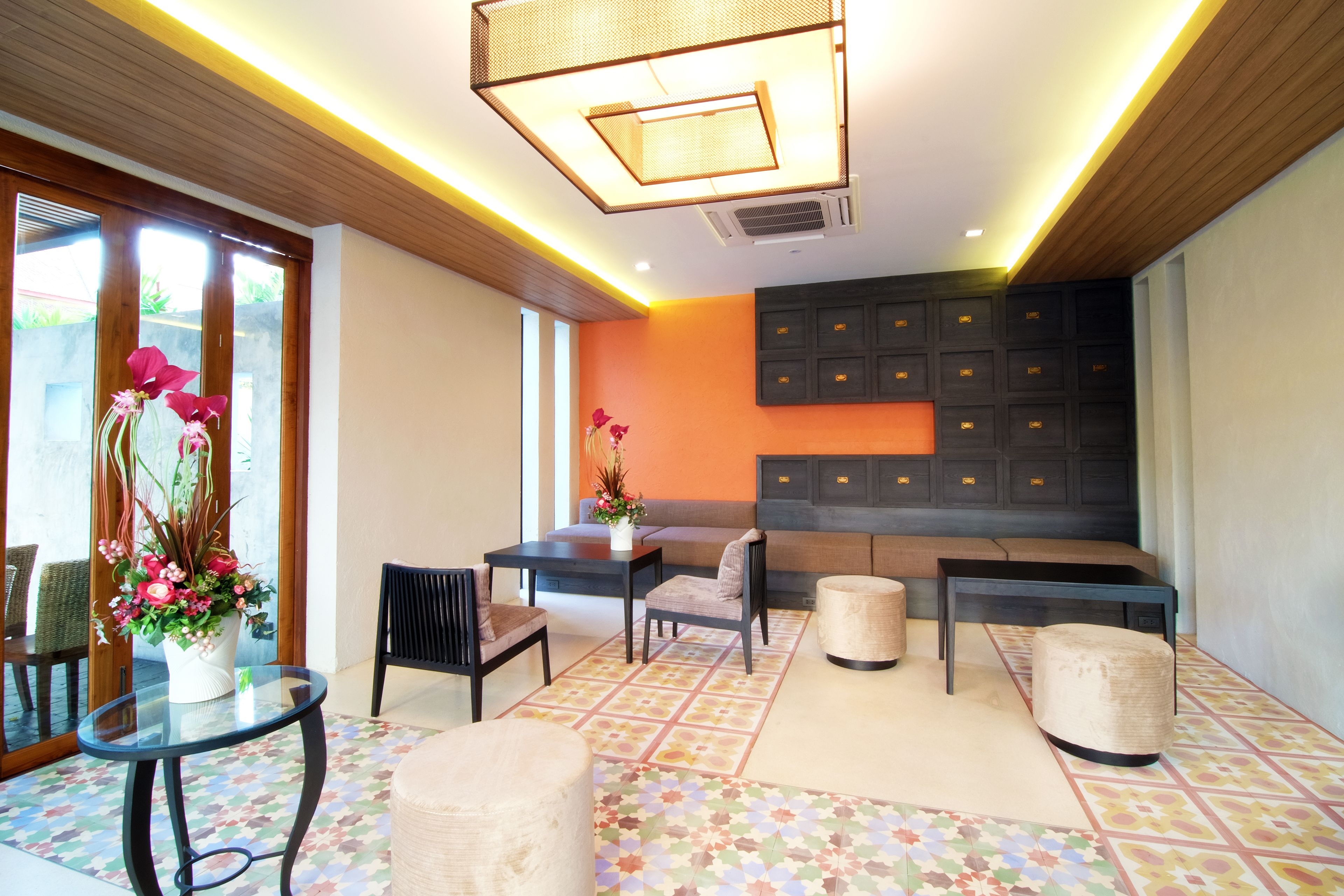 A modern lounge area with a sofa, chairs, a small table, and a decorative vase.