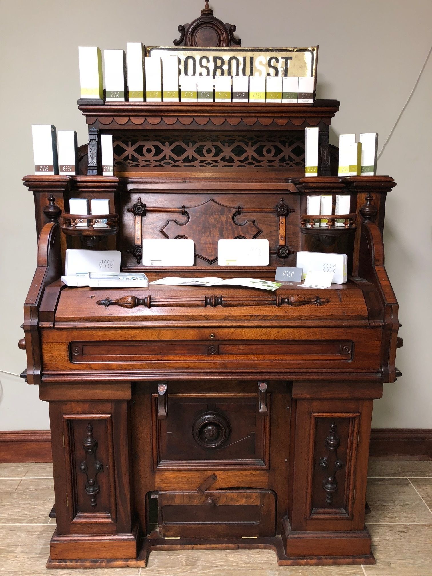 Un vieux piano en bois, avec une pancarte au-dessus portant l’inscription « BOSBOUSST ST. »