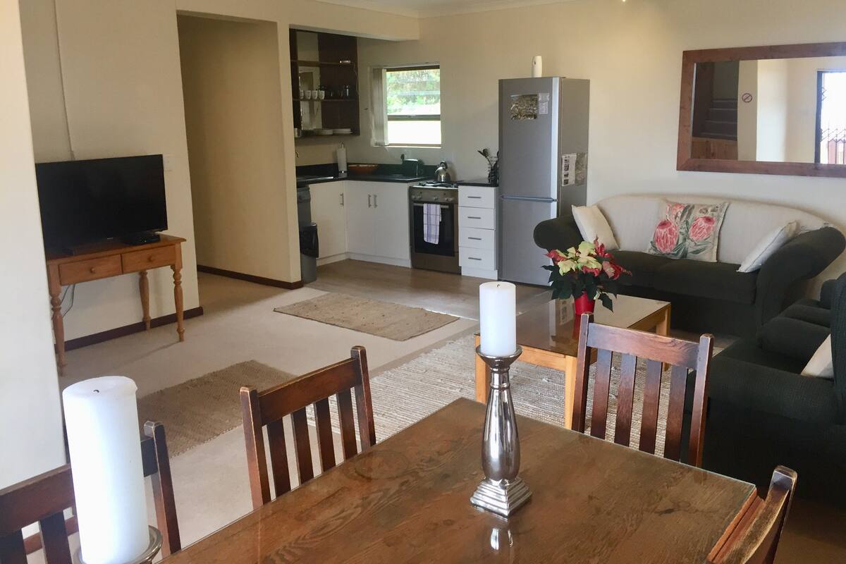 A compact living space with a dining area, kitchen, and a sofa.
