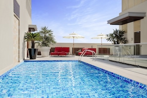 Piscine extérieure, parasols de plage, chaises longues