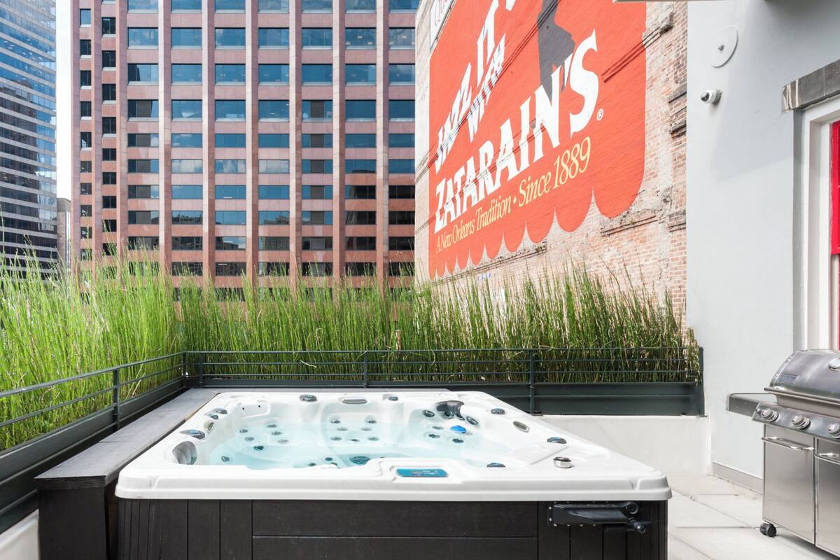 A rooftop patio with a hot tub, a grill, and a large billboard advertising Zatarain's.