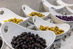 Una hilera de tazones blancos y de formas singulares, llenos de granos de distintos colores.