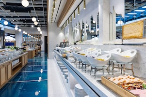 Una presentación de buffet moderna con cuencos blancos y diversas opciones de comida.