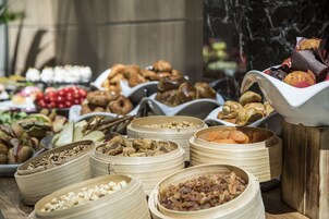 A buffet with various food items in bamboo containers.