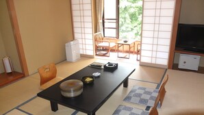 A traditional Japanese room with tatami flooring, a low table with a bowl and a cup, and a television on a cabinet. - Nikko Green Hotel Natsukashiya Fuwari (Nikko)
