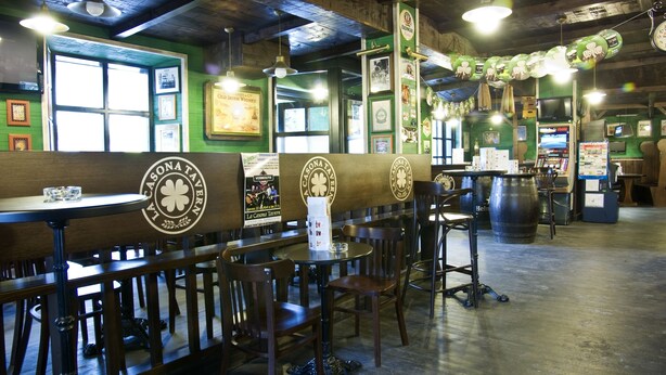 A restaurant interior with wooden booths, green walls, and various framed pictures. - La Casona de Luis (Santillana del Mar)