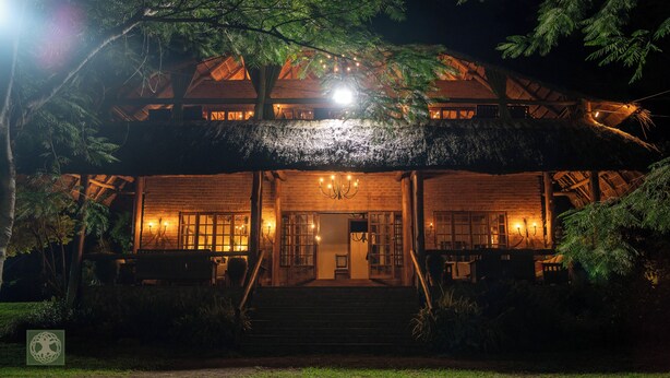 A rustic lodge with a thatched roof, wooden exterior, and a staircase leading to the entrance. - Kumbali Country Lodge (Lilongwe)