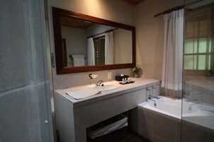 Un baño con lavamanos doble, un espejo grande y una bañera.