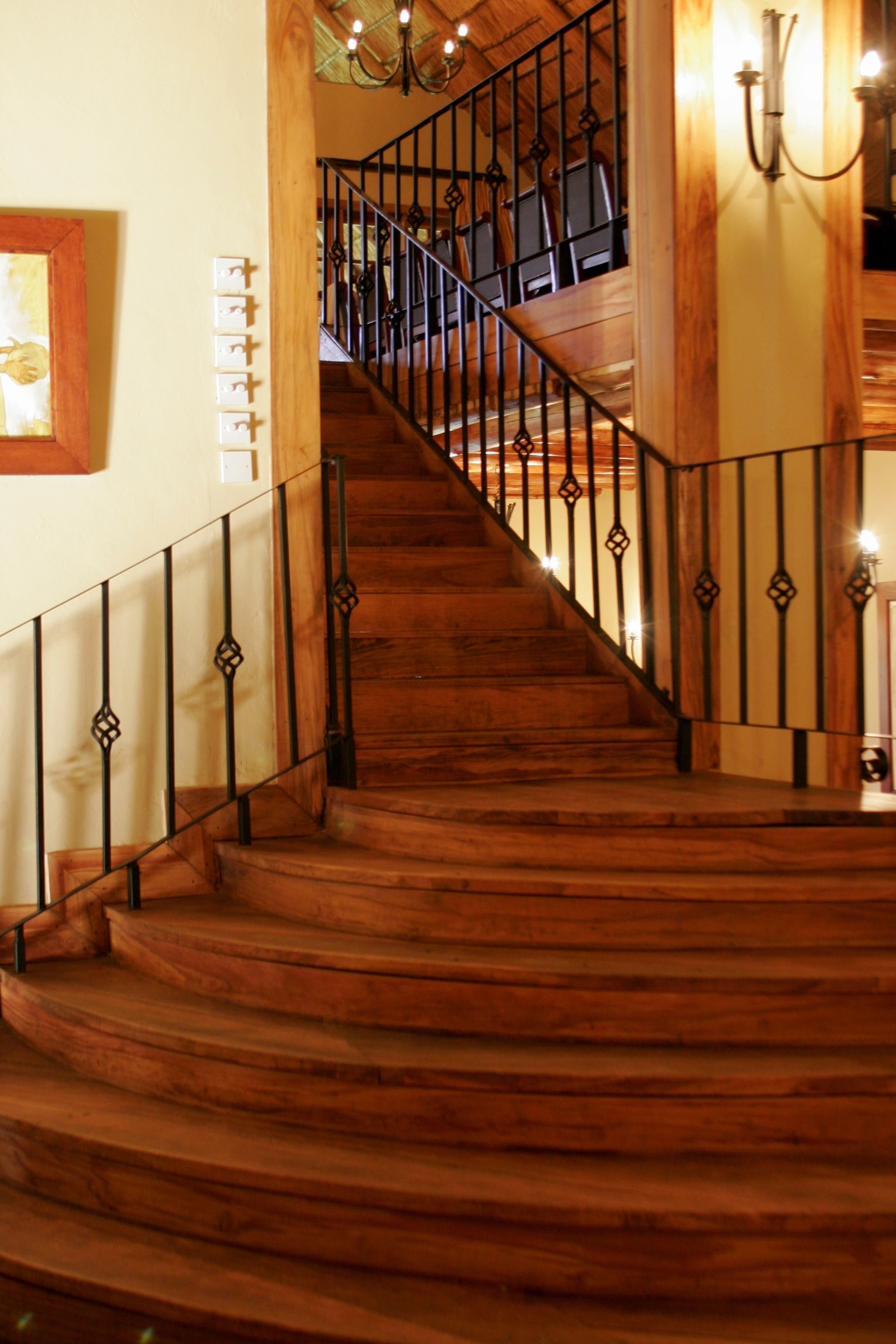 Un escalier en bois avec des rampes noires menant à l’étage supérieur.