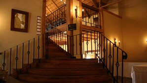 A wooden staircase with wrought iron railings leading to an upper level. - Kumbali Country Lodge (Lilongwe)