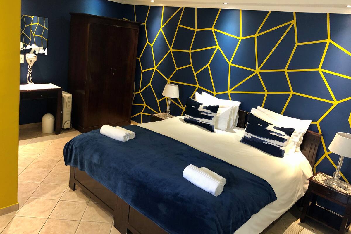 Una habitación de hotel con cama, mesitas de noche, armario y baño.