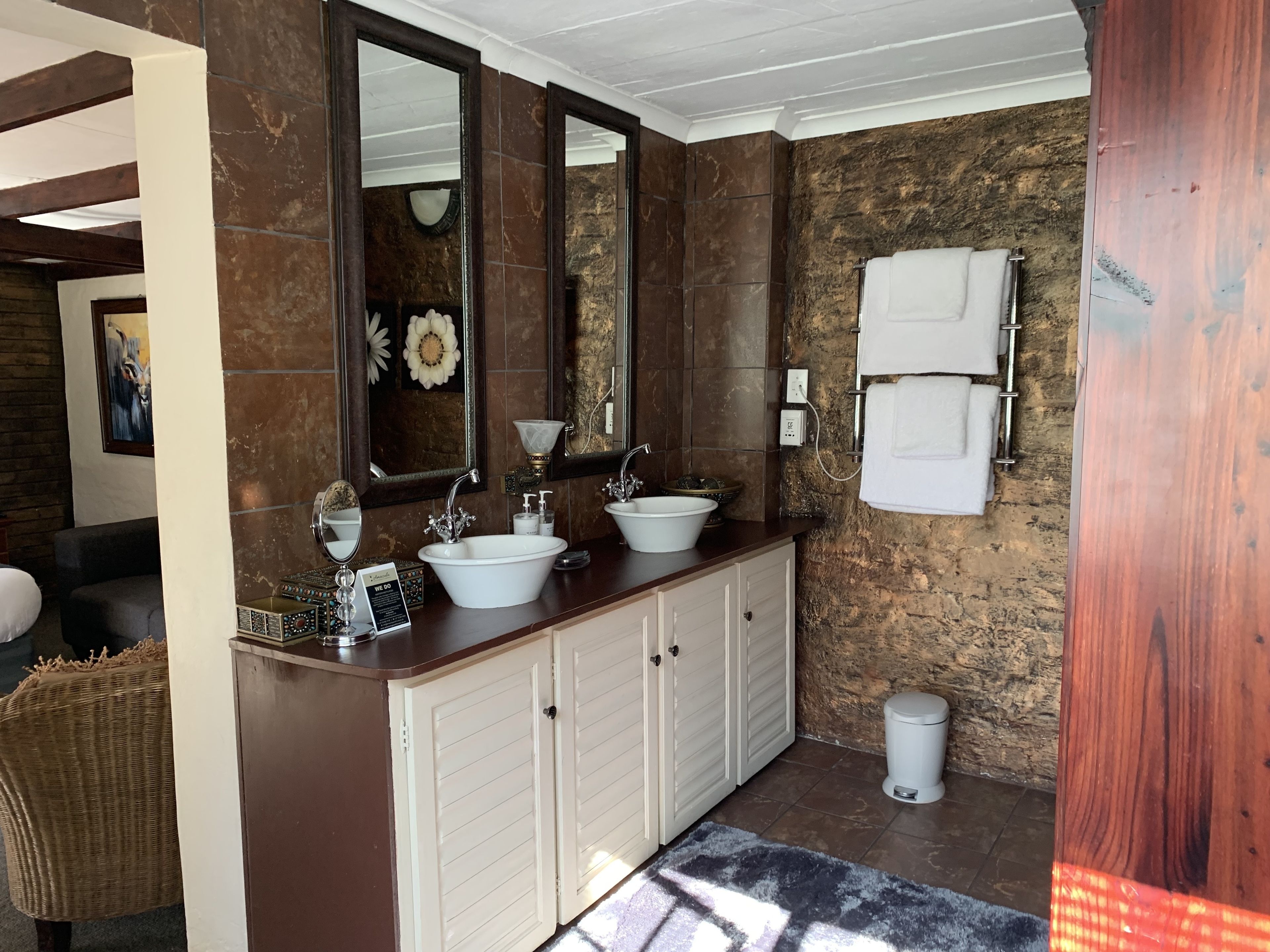 A bathroom with two sinks, a large mirror, and a towel rack.