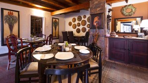 Comedor con una mesa redonda dispuesta para seis personas, rodeada de sillas de madera.