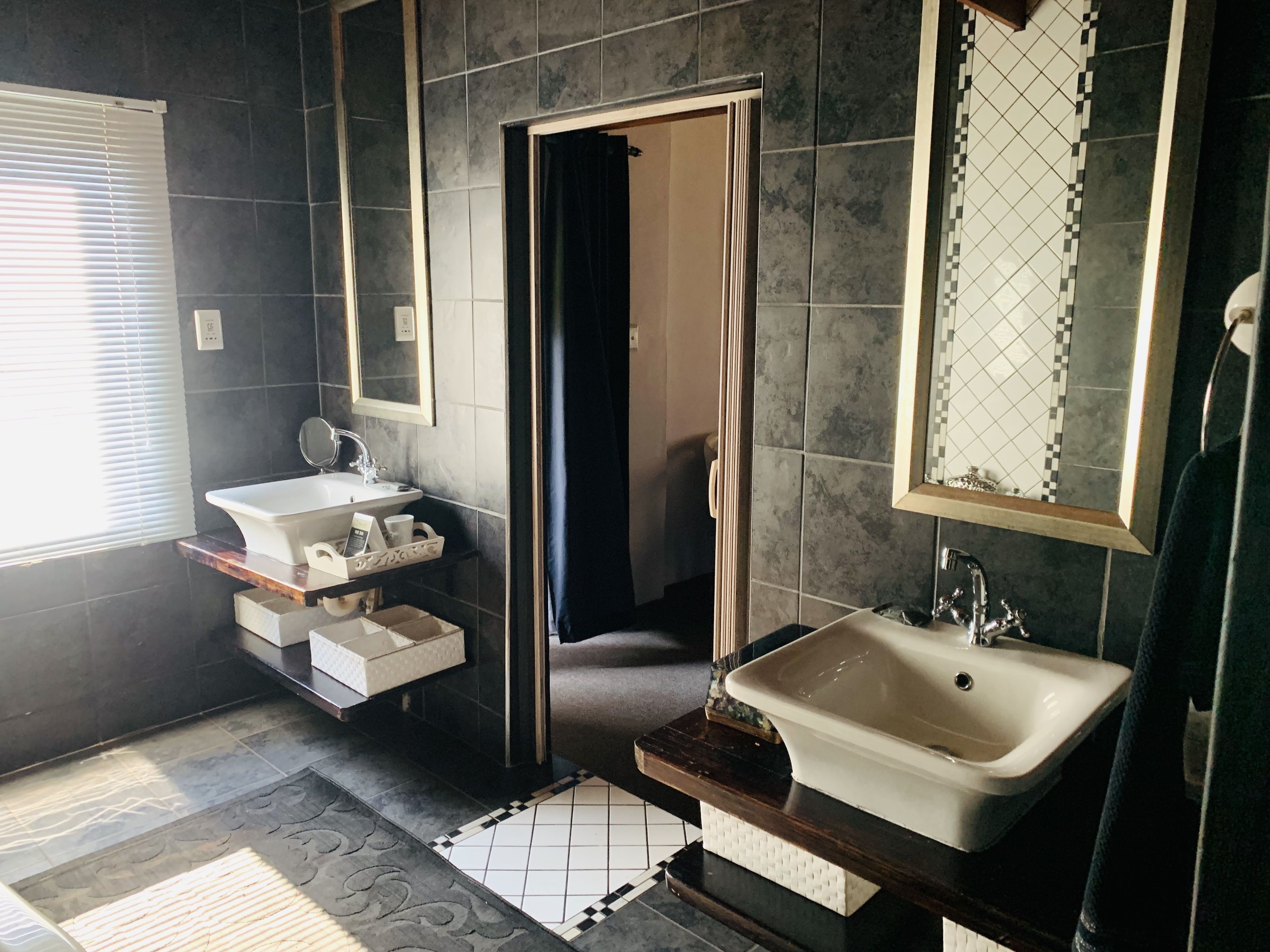 A modern bathroom with a large sink, mirror, and shower.