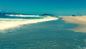 Una playa con agua turquesa cristalina y una orilla arenosa.