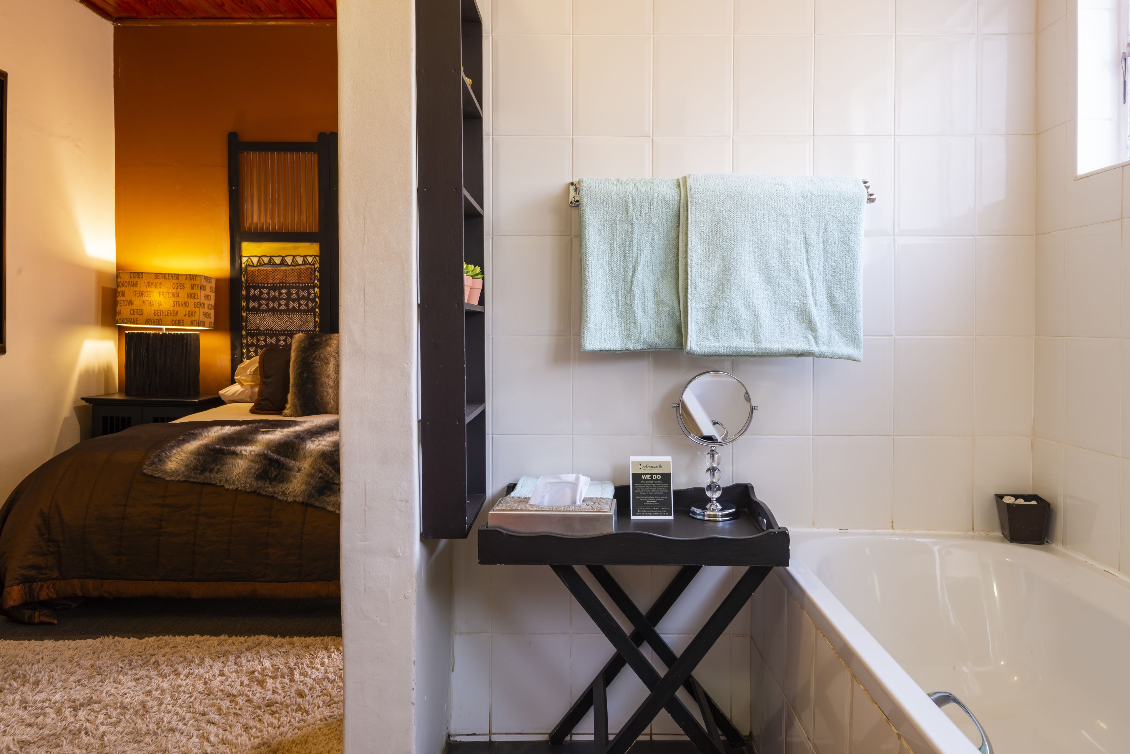 Une salle de bain avec une baignoire, un lavabo avec un miroir et deux serviettes accrochées au mur.