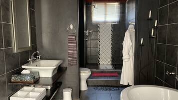 Un baño moderno con bañera, lavabo, inodoro y zona de ducha.