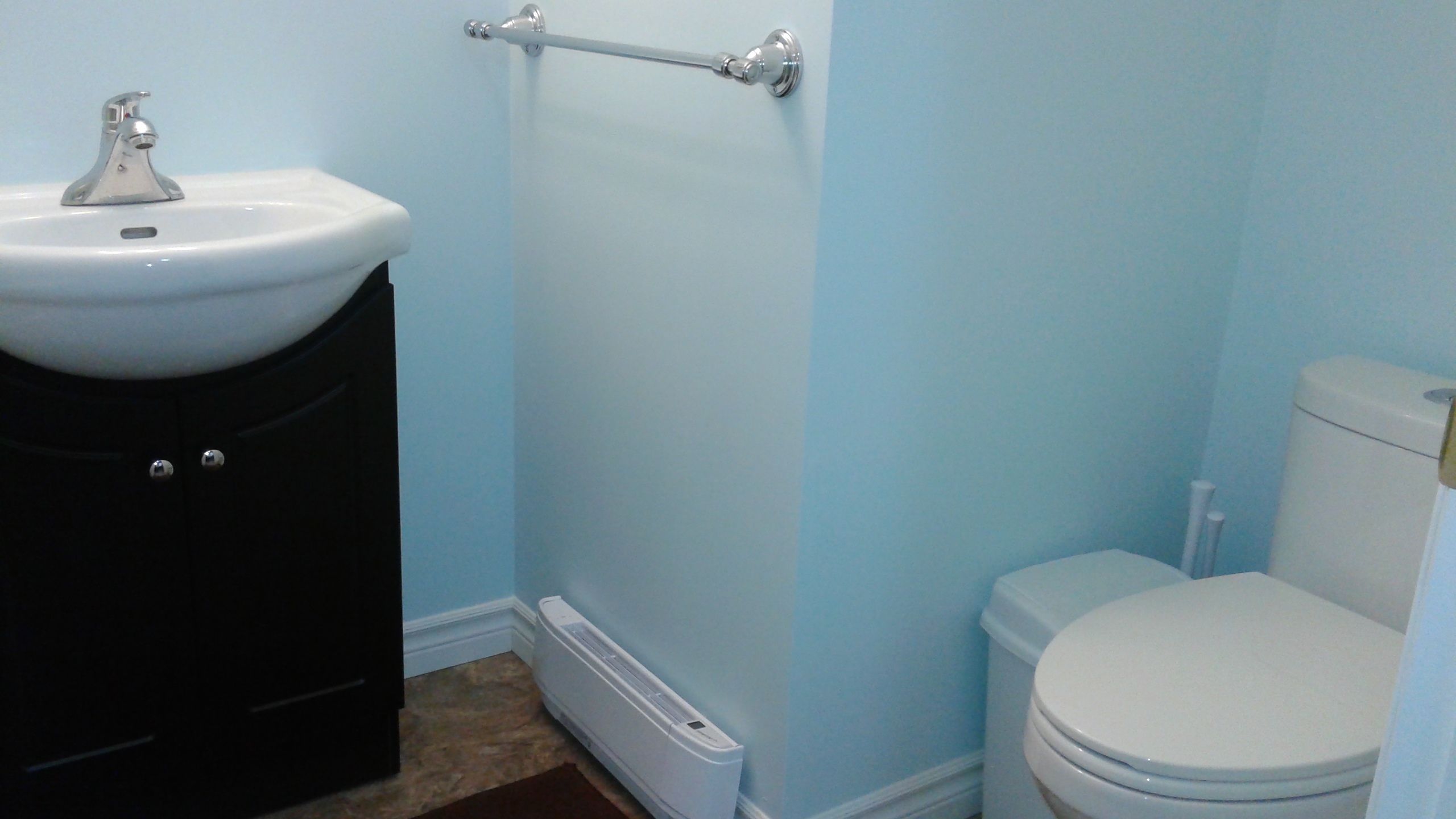A bathroom with a sink, toilet, and a shower area.