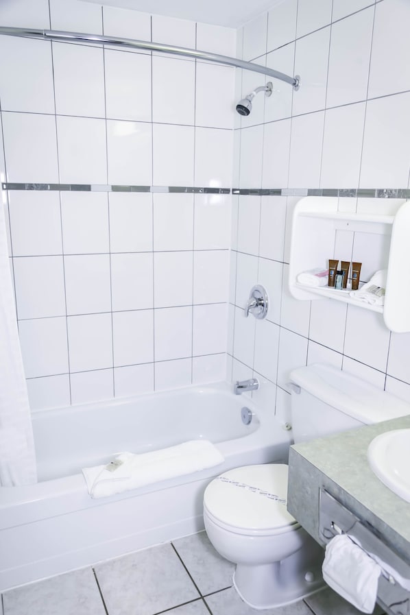 Un baño moderno con bañera, inodoro y zona de ducha.