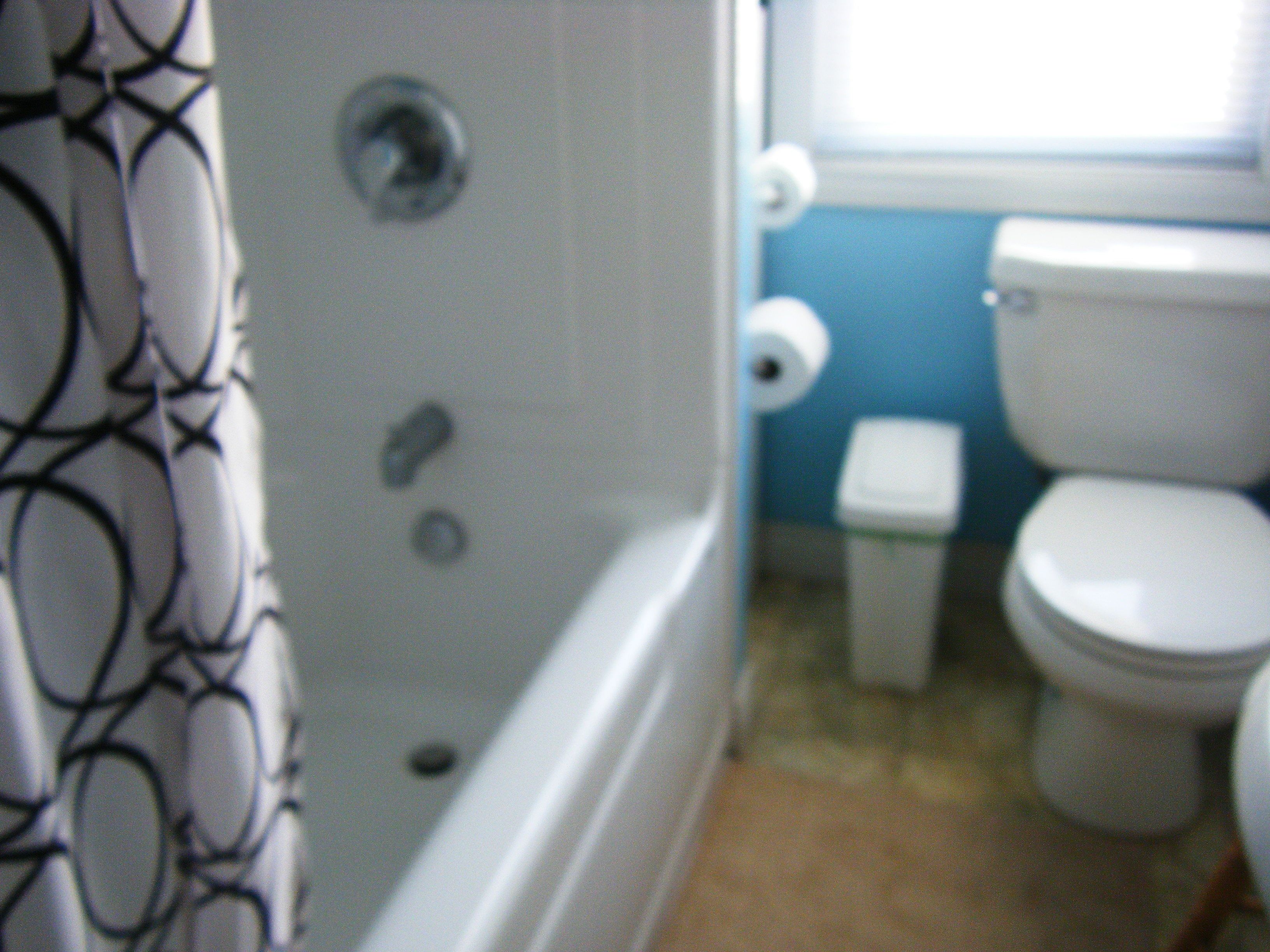 Un baño con bañera, inodoro y cortina de ducha.