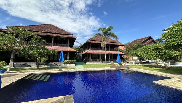 A resort with a swimming pool, multiple buildings with red-tiled roofs, and lush greenery. - Tulamben Wreck Divers (Tulamben)