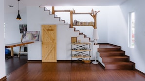 A spacious room with a wooden staircase, a desk with a chair, and a bookshelf. - Westwood Highland - Hostel (Kampung Raja)