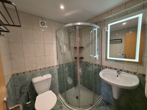 A bathroom with a glass-enclosed shower, a toilet, and a sink. - Bora Bora (Nessebar)