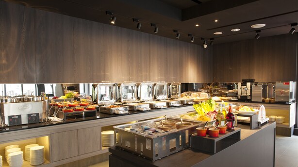Un buffet allestito con diverse postazioni gastronomiche e una macchina per caffè.