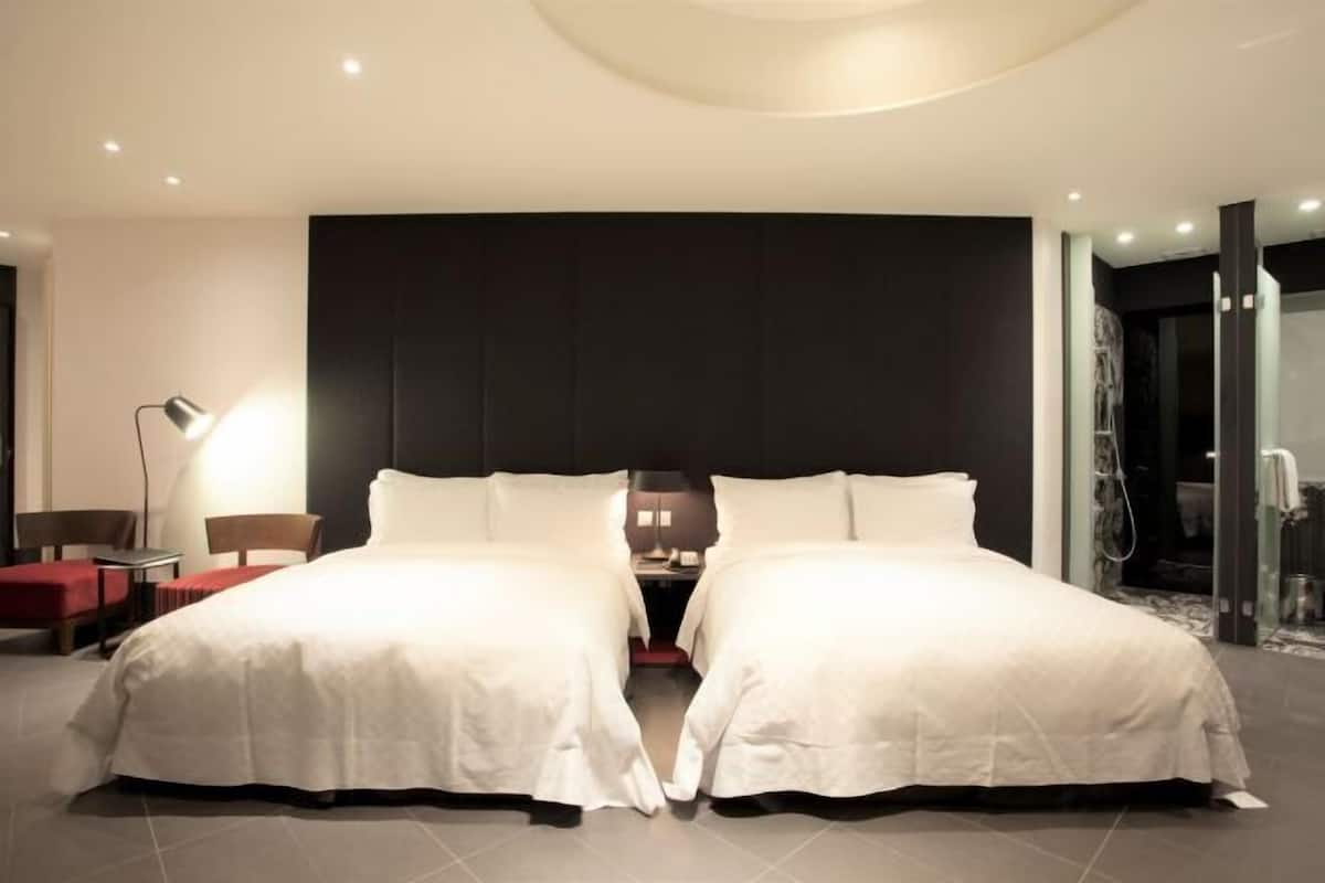 Ein modernes Hotelzimmer mit einem großen Bett, einem Schreibtisch und einem Sessel.