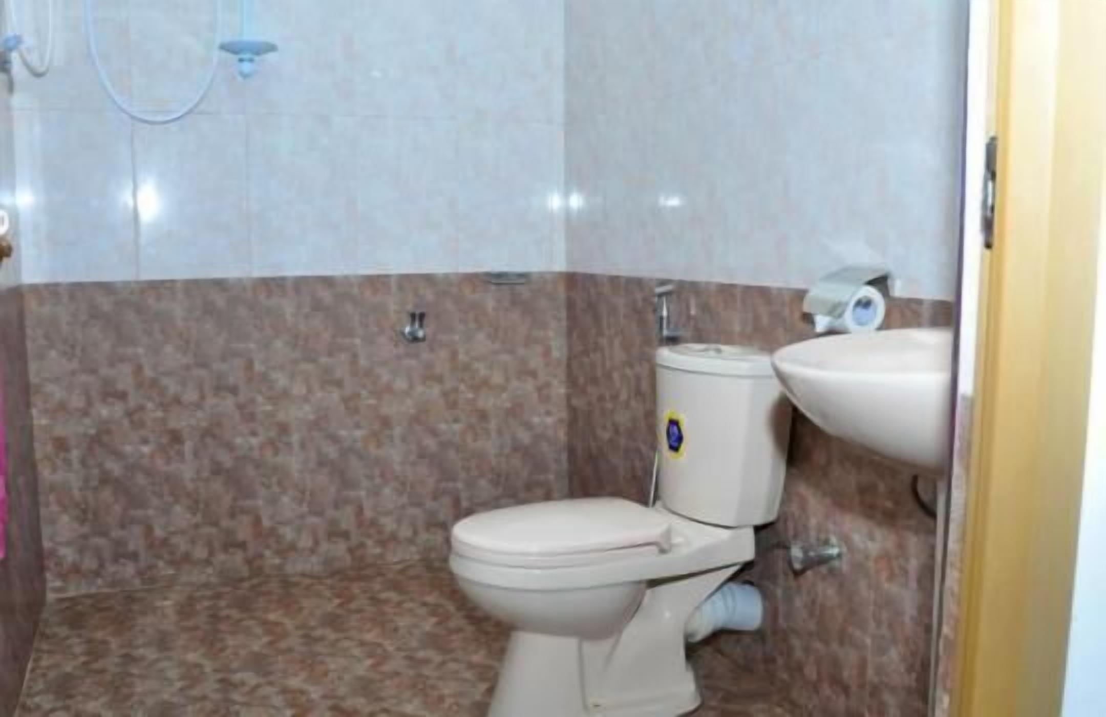 Un baño con inodoro, bidé y lavamanos.