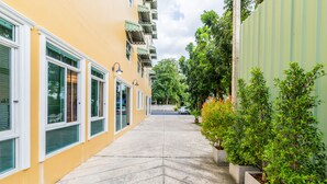 A narrow, paved walkway flanked by buildings with large windows and balconies.