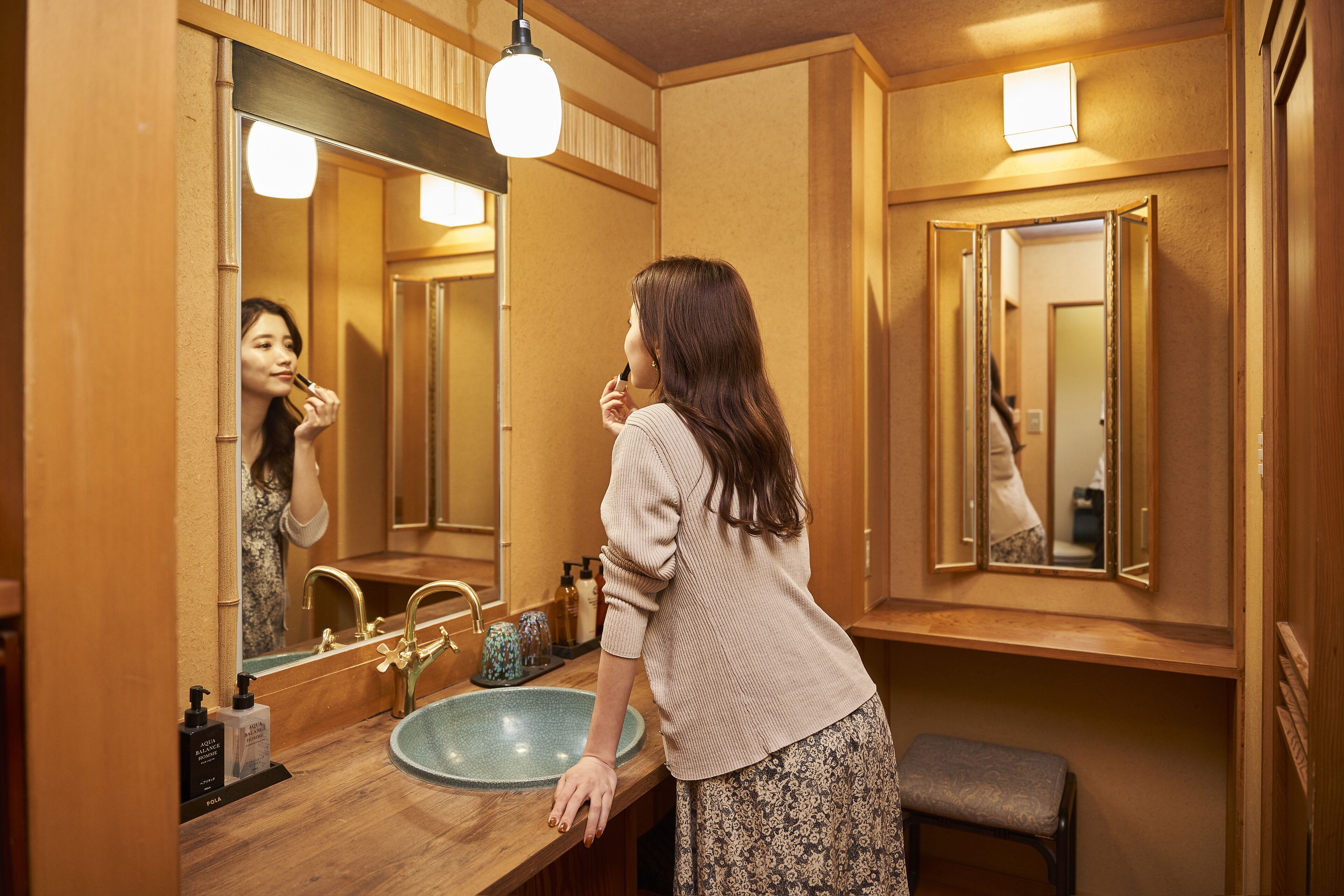 A bathroom with a wooden vanity, a sink, and a mirror.