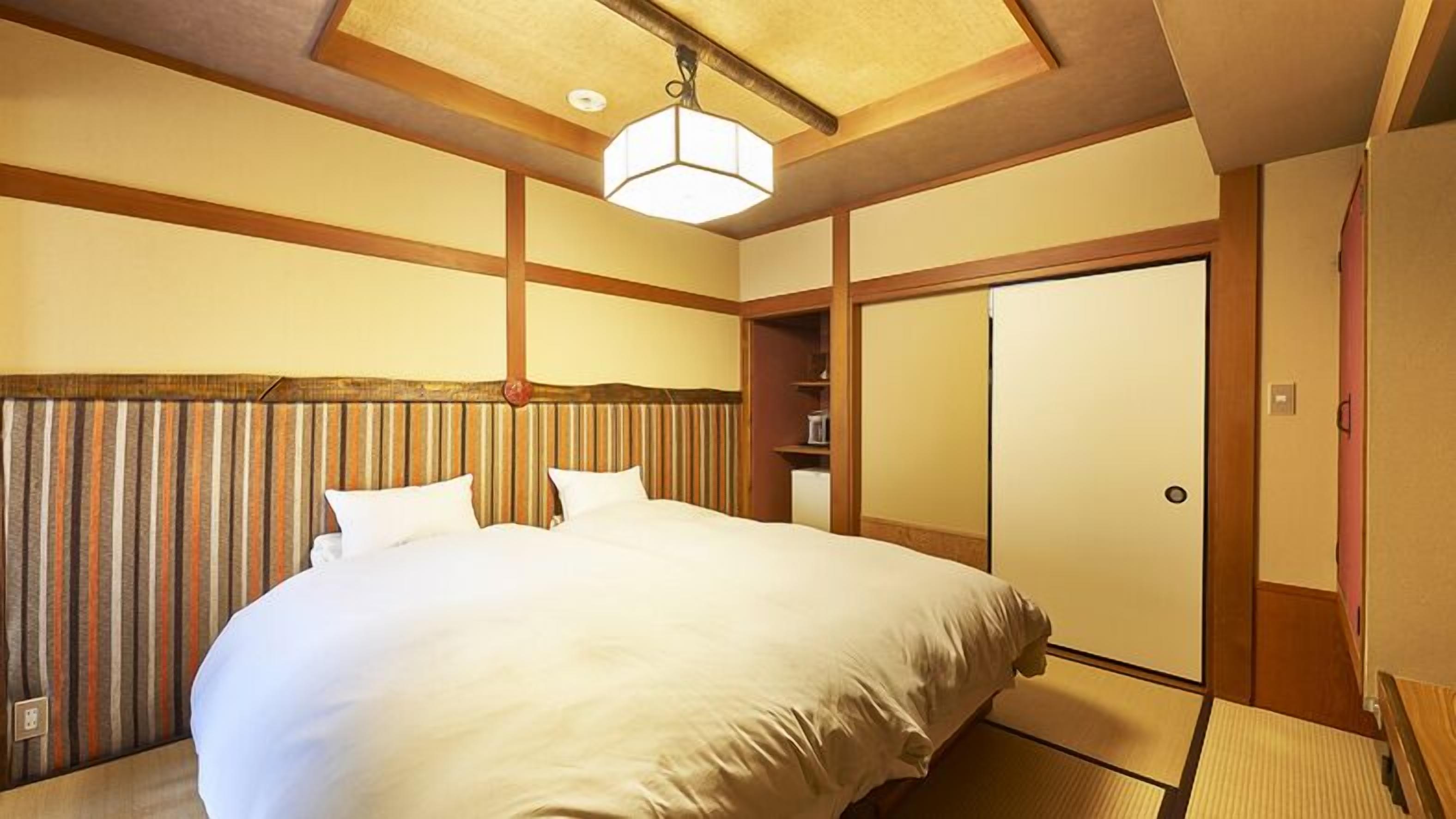 A hotel room with a large bed, wooden headboard, a wardrobe, and a ceiling light fixture.