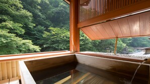 Eine traditionelle Holzbadewanne mit Blick auf üppiges Grün.