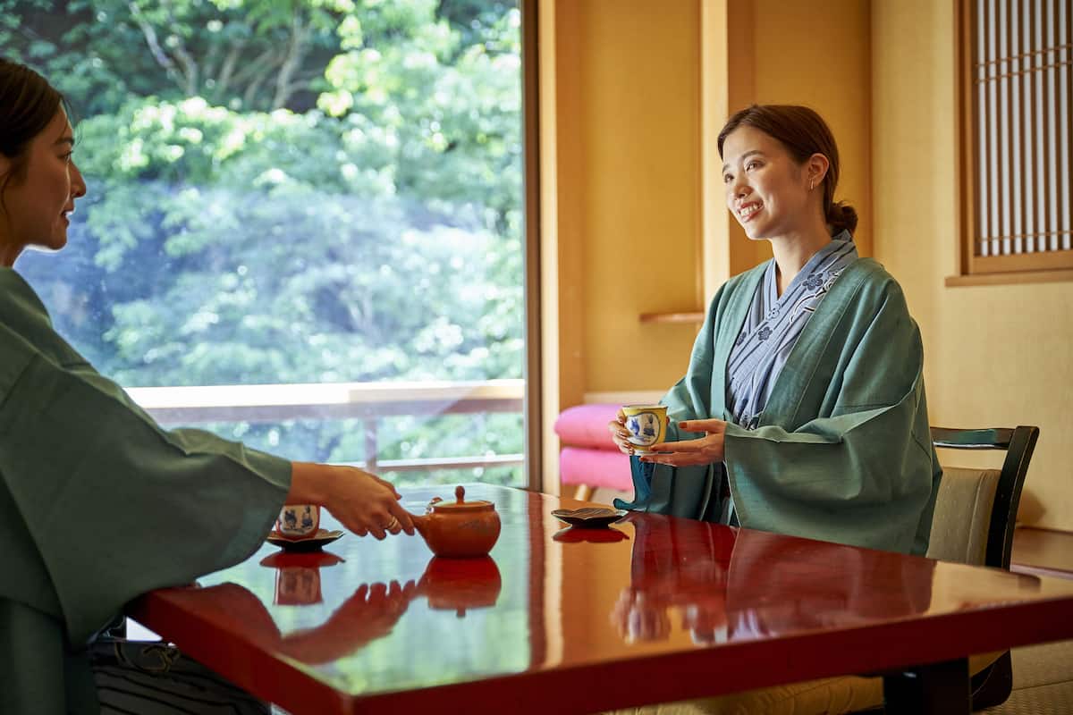A traditional tea ceremony setting with a wooden table, a teapot, and a cup.