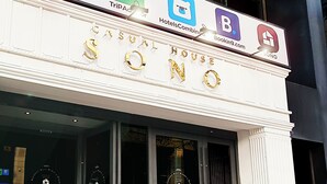 Een hotelgevel met logo's van Expedia, TripAdvisor, HotelsCombined, Booking.com en Sono.