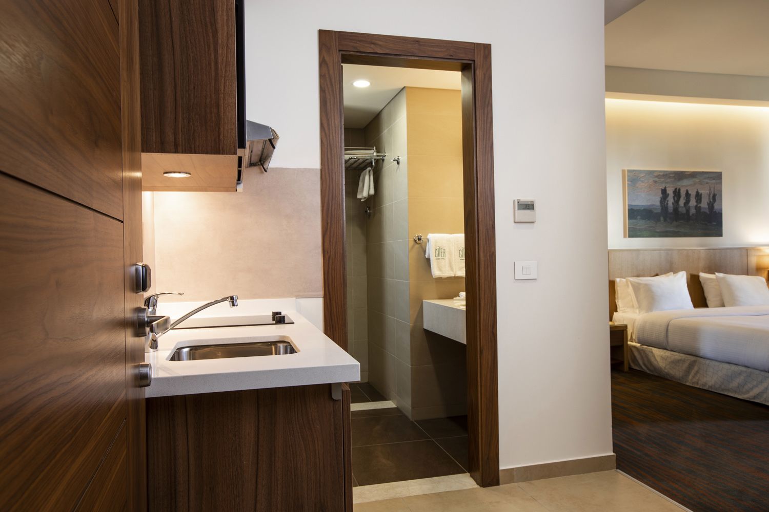 Un baño moderno con lavamanos, espejo y toallero.