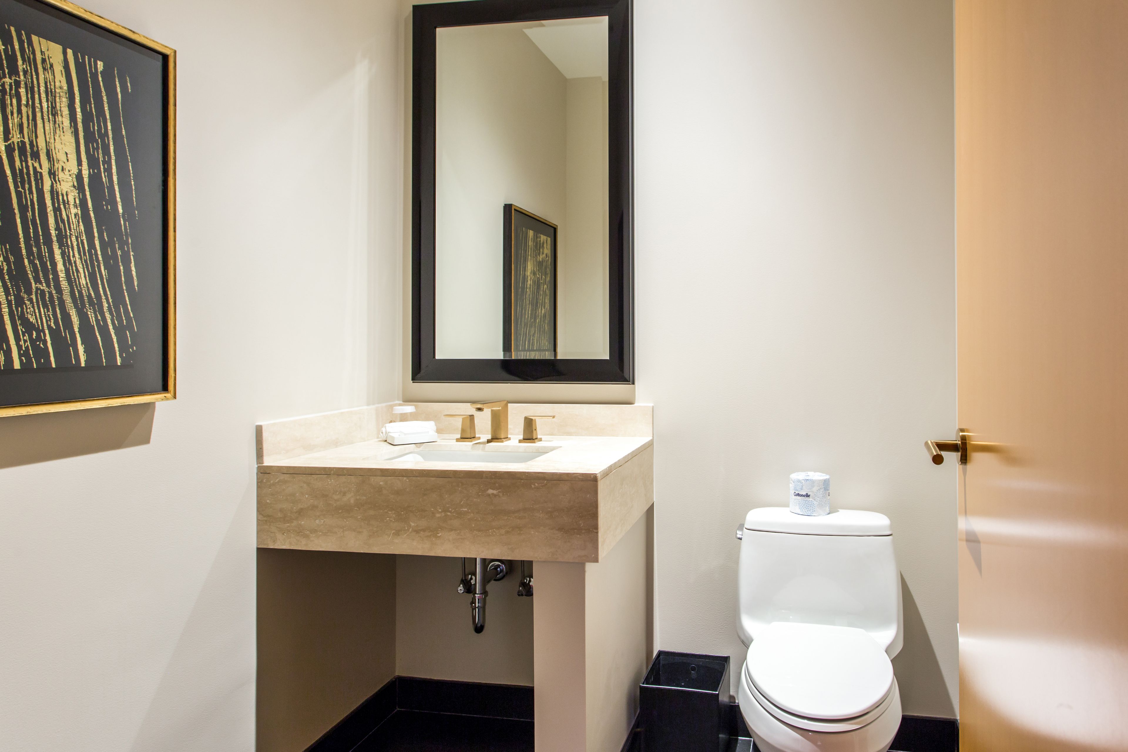 Une salle de bain avec un lavabo beige, un miroir et des toilettes.