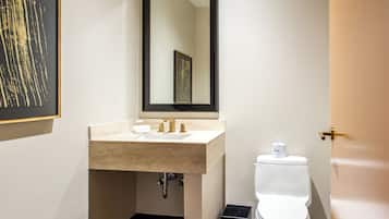 Une salle de bain avec un lavabo beige, un miroir et des toilettes.
