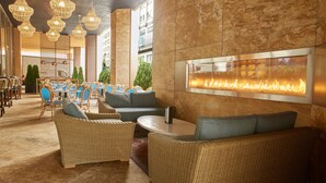 A lobby with wicker furniture, a fire feature, and a view of the outdoors. - Residence Inn Chicago Downtown Magnificent Mile (Chicago)