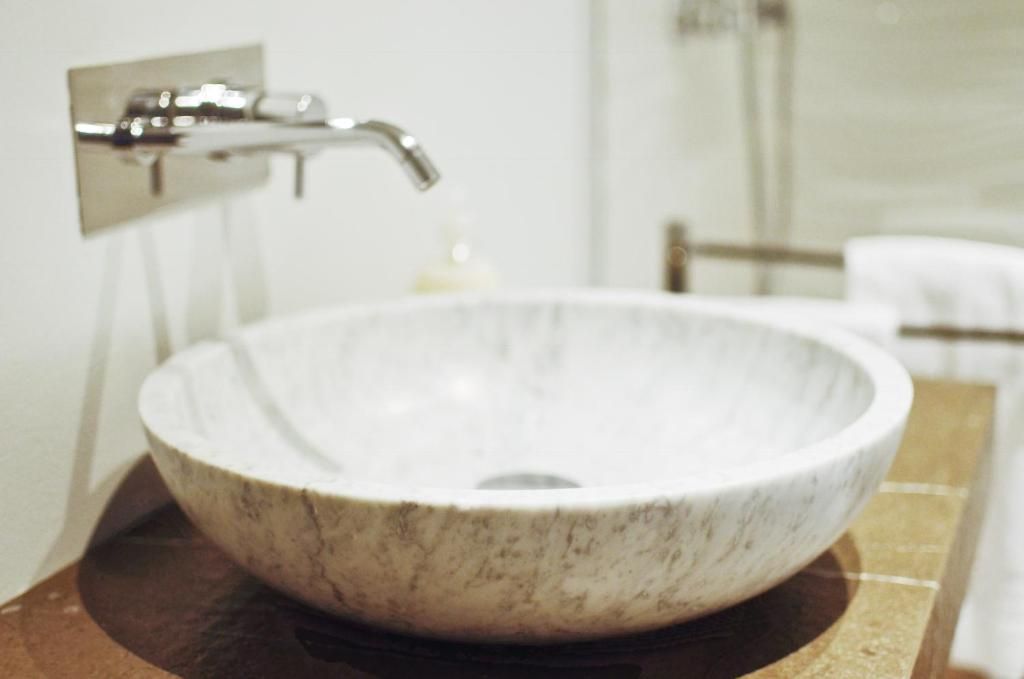 Un bagno con lavabo in marmo, rubinetto cromato e porta asciugamani.