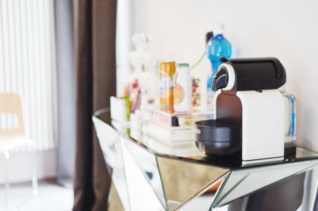 Une cuisine moderne équipée d’une machine à café, d’un comptoir en verre et de divers ustensiles de cuisine.