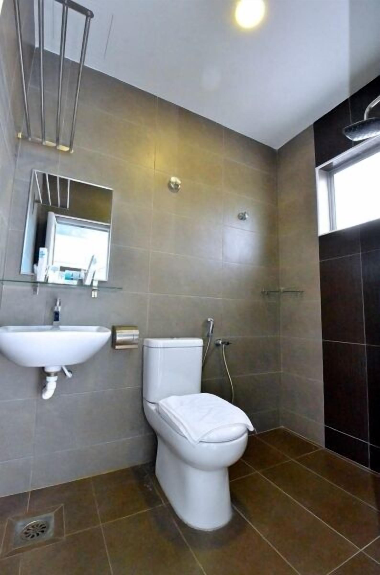 A modern bathroom with a toilet, sink, and shower.